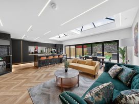 A living room with a kitchen island and dining area at Ty Uchel 