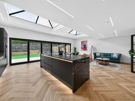 A kitchen with a large island and sliding doors at Ty Uchel