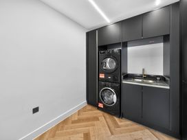 A laundry room with a washing machine, dryer, and sink at Ty Uchel