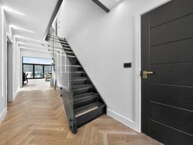 A hallway with a staircase and a window at Ty Uchel