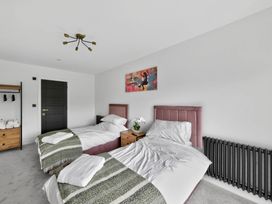 A bedroom with two beds and a nightstand at Ty Uchel