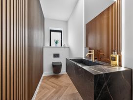 A bathroom featuring a sink and toilet at Ty Uchel