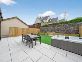 A garden with a table and chairs and a hot tub at Ty Uchel in 
