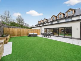 A garden with a hot tub and seating area at Ty Uchel