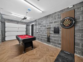 A game room with a pool table and dartboard at Ty Uchel