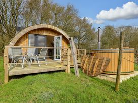 A cabin with a deck and hot tub at Grape Escape near Halesworth