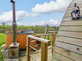 A hot tub with a chimney and wooden deck at Grape Escape near Halesworth