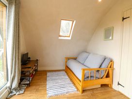 A living room with a sofa and a television at Grape Escape near Halesworth