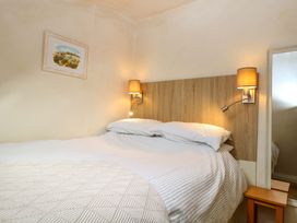 A bedroom with a bed and bedside table at Grape Escape near Halesworth