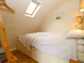 A bedroom with a bed and shelf at Grape Escape near Halesworth