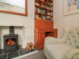 A living room with a fireplace and bookshelf at Ivy Cottage Dartmouth