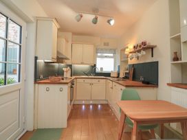 A kitchen with cabinets and countertop at Ivy Cottage in Dartmouth