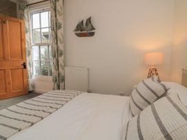 A bedroom with bed and window at Ivy Cottage in Dartmouth