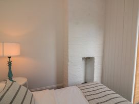 A bedroom with a lamp and bed at Ivy Cottage Dartmouth