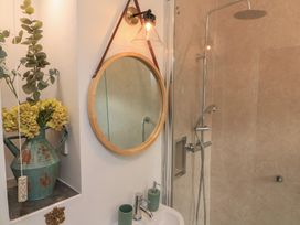 A shower area with a mirror and sink at Ivy Cottage in Dartmouth