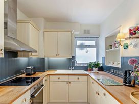 A kitchen with a sink and kitchen cabinets at Ivy Cottage in Dartmouth
