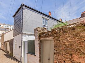 A building with a window and door in an outdoor alley at Ivy Cottage Dartmouth