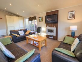 A living room with a television and coffee table at Kingfisher Lodge
