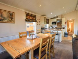 A dining area with a table and chairs at Kingfisher Lodge 