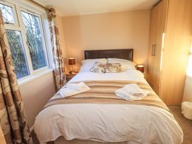 A bedroom with a bed and window at Kingfisher Lodge