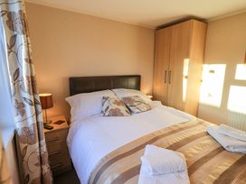 A bedroom with a bed and wardrobe at Kingfisher Lodge