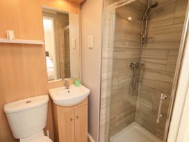 A bathroom featuring a sink, toilet, and shower at Kingfisher Lodge