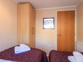 A bedroom with a bed and wardrobe at Kingfisher Lodge