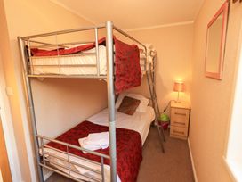 A bedroom with a bunk bed and bedside table at Kingfisher Lodge 
