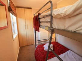 A bedroom with a bunk bed and wardrobe at Kingfisher Lodge 