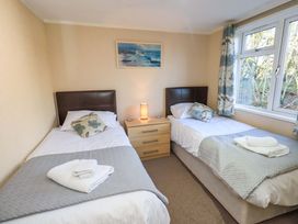 A bedroom with two beds and a lamp at Kingfisher Lodge