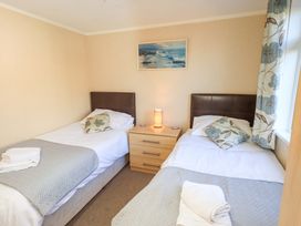 A bedroom with two single beds and a nightstand at Kingfisher Lodge