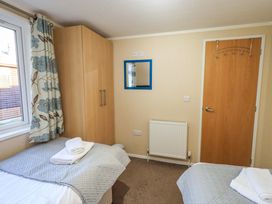 A bedroom with a bed and wardrobe at Kingfisher Lodge