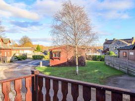 An outdoor view of cabins and a tree at Kingfisher Lodge