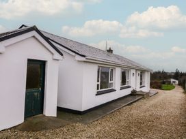 A house with a green door and windows at Bungalow Falcarragh in Falcarragh, County Donegal