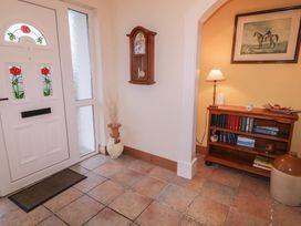 A hallway with a front door and a clock at Bungalow Falcarragh, Falcarragh, County Donegal