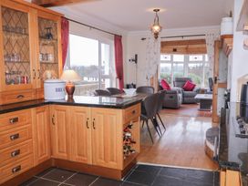 A kitchen with wooden cabinets and a living area at Bungalow Falcarragh, Falcarragh, County Donegal