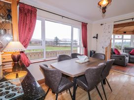 A dining room with a table and chairs with a view at Bungalow Falcarragh in Falcarragh, County Donegal