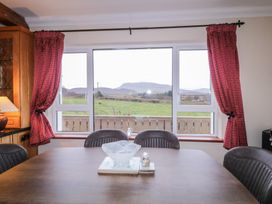 A dining room with a table and chairs and a view of the landscape at Bungalow Falcarragh in Falcarragh, County Donegal