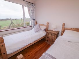 A bedroom with twin beds and a nightstand at Bungalow Falcarragh, Falcarragh, County Donegal