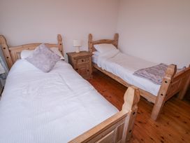 A bedroom with two beds and a nightstand at Bungalow Falcarragh in Falcarragh, County Donegal