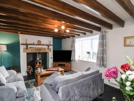 A living room with a fireplace and sofa at Cheyne Cottage in Fylingthorpe