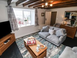 A living room with a sofa, coffee table and television at Cheyne Cottage in Fylingthorpe