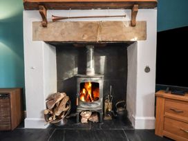 A fireplace and wood stove in a living room at Cheyne Cottage Fylingthorpe