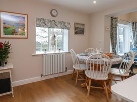 A dining room with a round table and chairs at Cheyne Cottage in Fylingthorpe