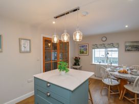 A kitchen with a dining area and a kitchen island at Cheyne Cottage in Fylingthorpe