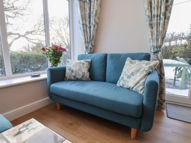 A snug with a blue sofa and flower vase at Cheyne Cottage Fylingthorpe