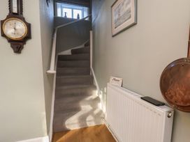A hallway with a staircase and wall decor at Cheyne Cottage in Fylingthorpe