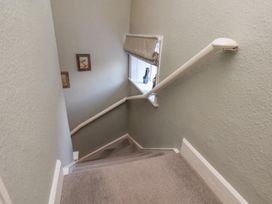 A staircase with a handrail and framed pictures at Cheyne Cottage in Fylingthorpe