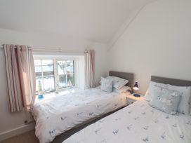 A bedroom with two beds and a window at Cheyne Cottage in Fylingthorpe