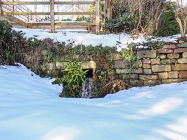 A garden with snow covering and a drain at Cheyne Cottage in Fylingthorpe